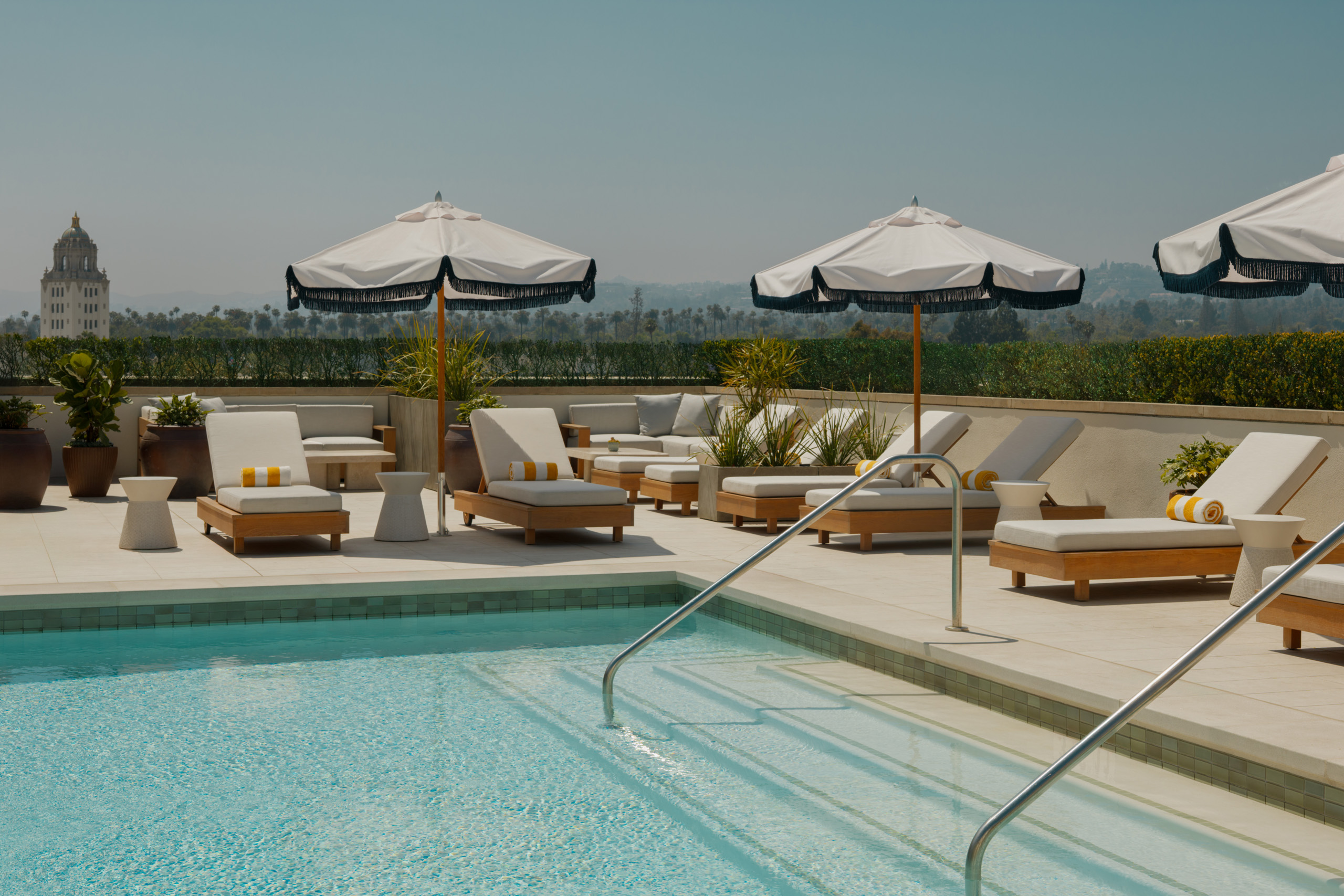 The rooftop pool at L’Ermitage Beverly Hills, framed by greenery above the city
