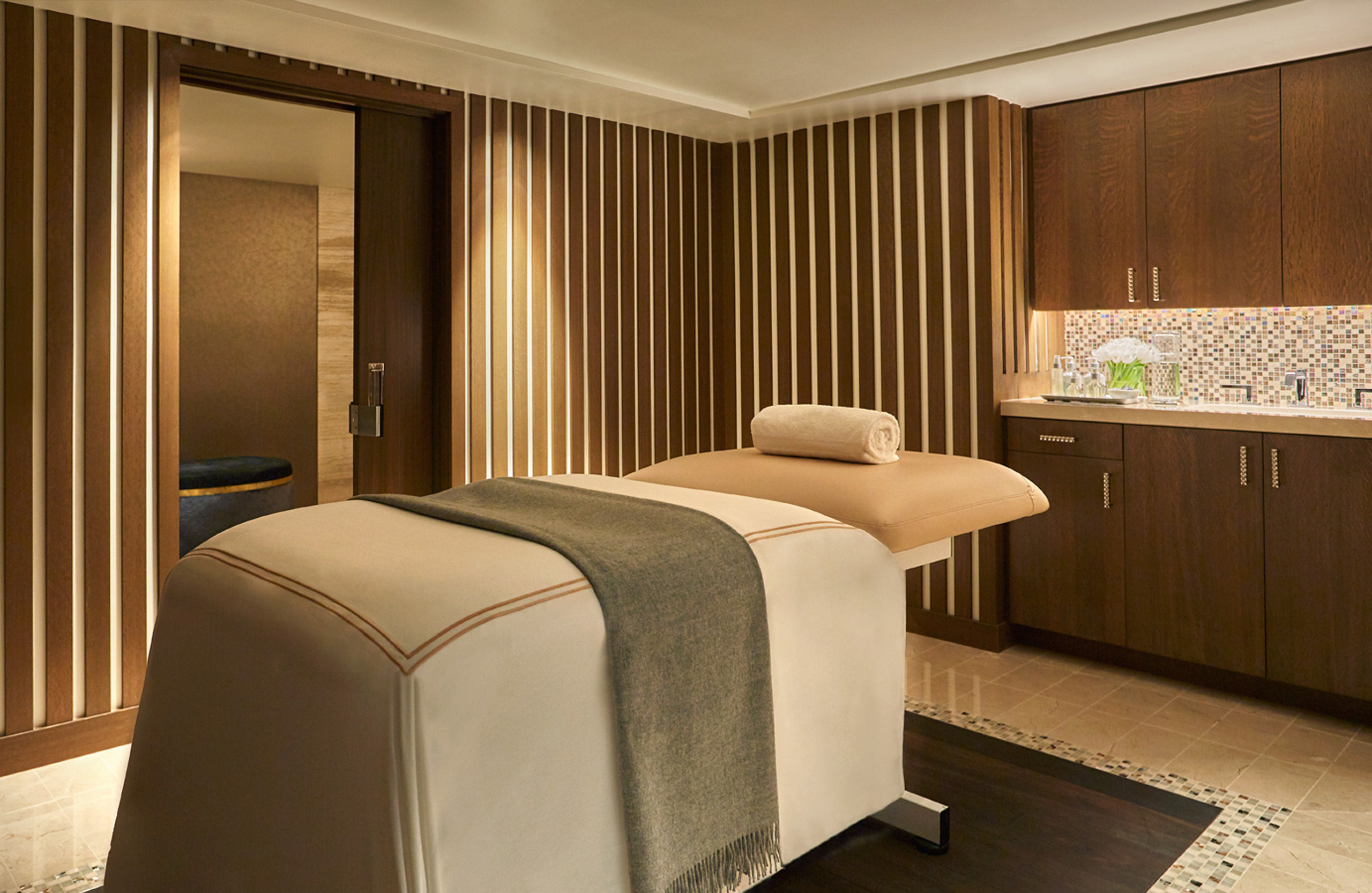 A L’Ermitage suite prepared as a private spa room, with a dressed treatment table